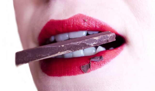 Woman biting and chocolate with Red Lipstick