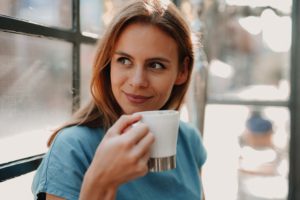 low cortisol signs Naomi Judge - woman with low hair smiling looking over her shoulder. She is holding a white cup with a silver bottom