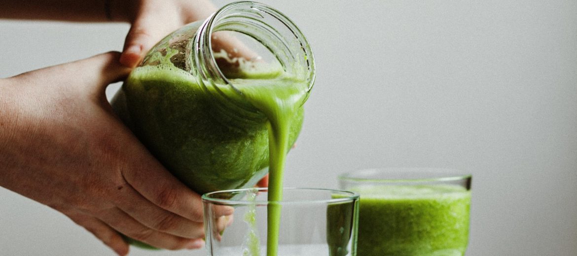 Cleaning Can Support Your Hormones - Here's How -Person pours green juice into a glass
