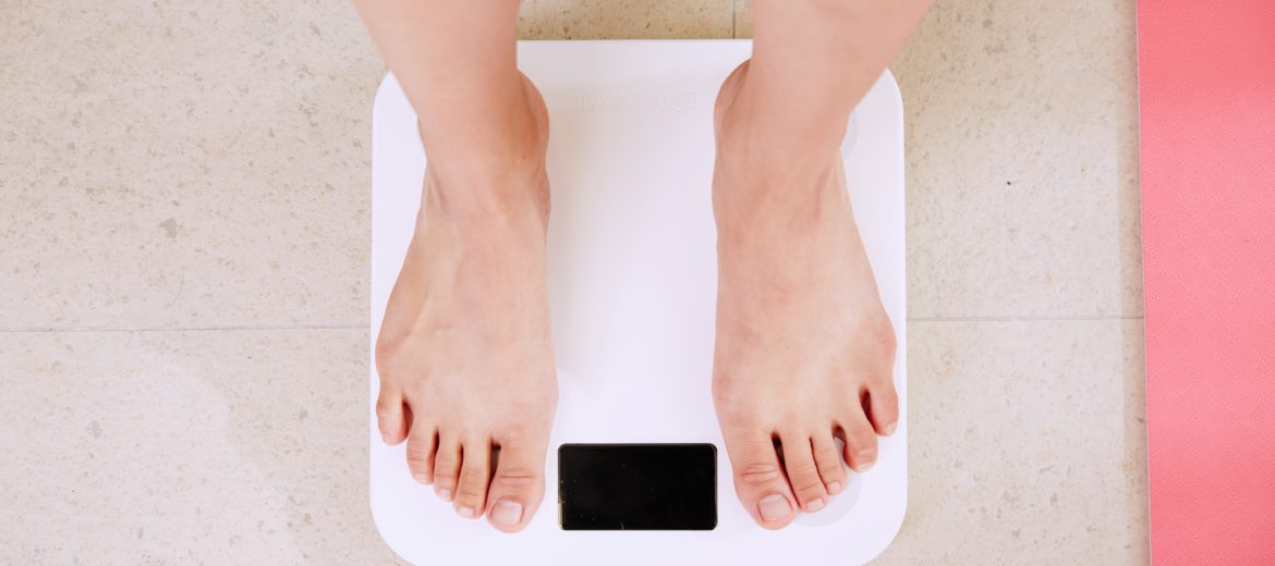 Want To Boost Your Metabolism? Try These 6 Nutrients - A pair of feet stand on a white scale